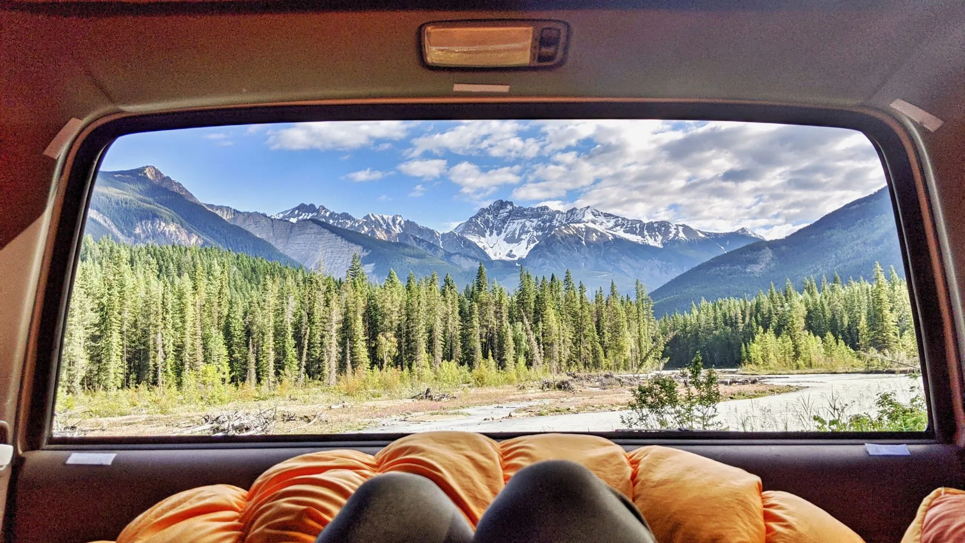 View through the back window of a car to mountains