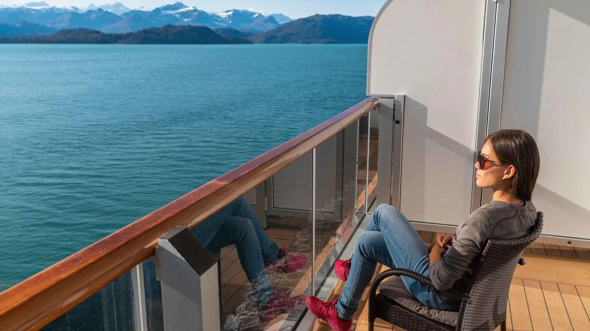 Celebrity Edge rooms to avoid (1) girl sitting on cruise ship balcony in stateroom